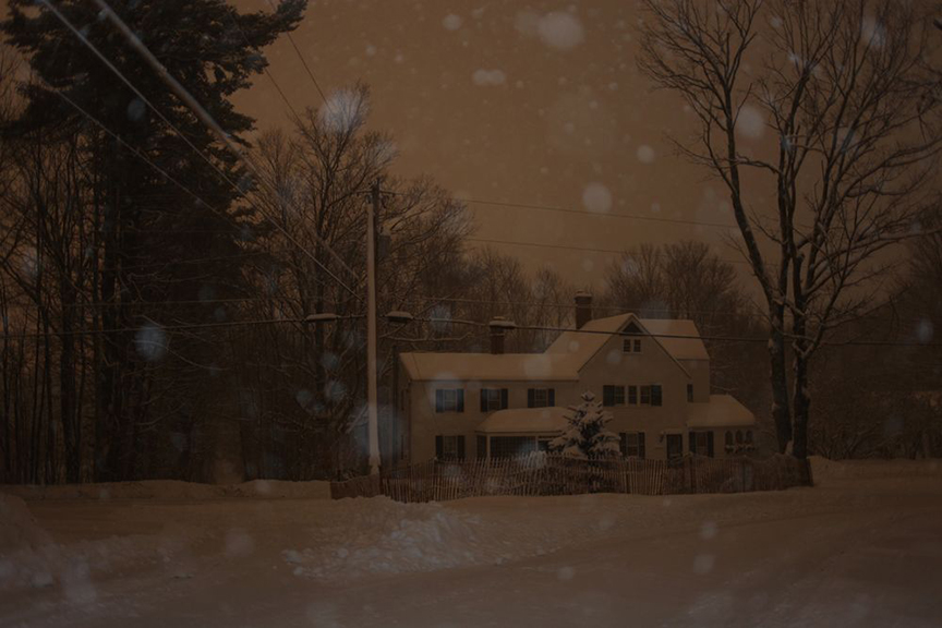 snow falling in front of colonial house